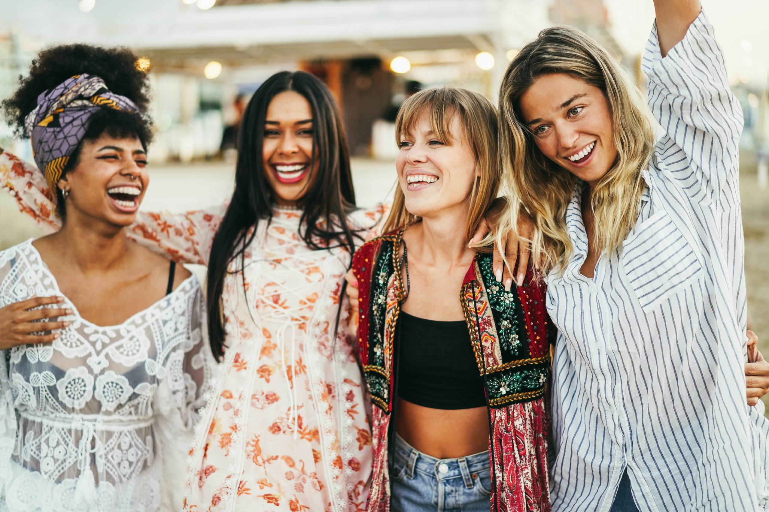 multiracial happy friends having fun outdoor at beach party focus on girl wearing black shirt